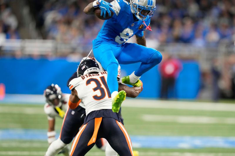 Detroit Lions wide receiver Jameson Williams (9) jumps over Chicago Bears safety Kevin Byard III (31) during the second half of an NFL football game in Detroit, Thursday, Nov. 28, 2024. (AP Photo/Carlos Osorio)