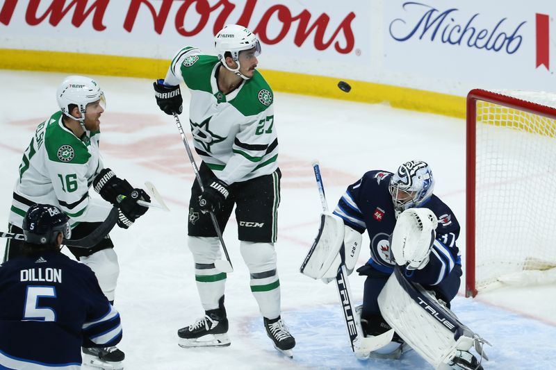 Nov 11, 2023; Winnipeg, Manitoba, CAN;  Dallas Stars forward Sam Steel (18) tries to deflect the puck pact Winnipeg Jets goalie Connor Hellebuyck (37) during the third period at Canada Life Centre. Mandatory Credit: Terrence Lee-USA TODAY Sports