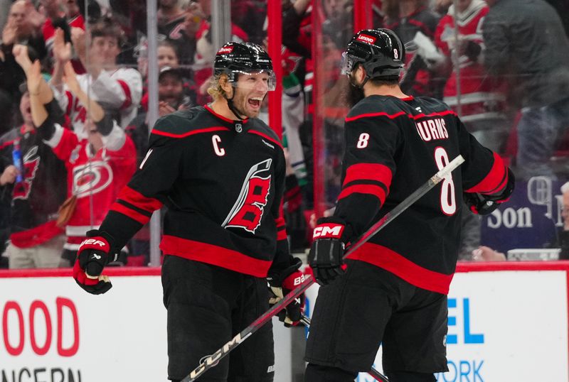 Nov 25, 2024; Raleigh, North Carolina, USA;  Carolina Hurricanes defenseman Brent Burns (8) celebrates his goal with  center Jordan Staal (11) against the Dallas Stars during the third period at Lenovo Center. Mandatory Credit: James Guillory-Imagn Images