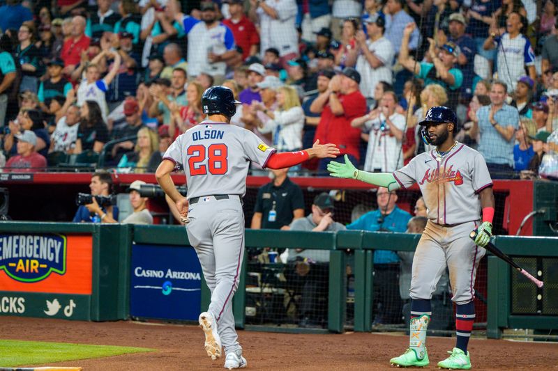 Apr 26, 2025; Phoenix, Arizona, USA;  Atlanta Braves infielder Matt Olson (28) and infielder Ozzie Albies (1) celebrate after Olson scores in the seventh inning against the Arizona Diamondbacks at Chase Field. Mandatory Credit: Allan Henry-Imagn Images