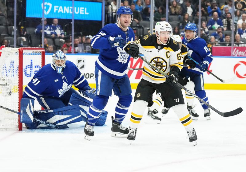 Nov 5, 2024; Toronto, Ontario, CAN; Boston Bruins left wing Brad Marchand (63) battles with Toronto Maple Leafs defenseman Morgan Rielly (44) in front of goaltender Anthony Stolarz (41) during the second period at Scotiabank Arena. Mandatory Credit: Nick Turchiaro-Imagn Imagess