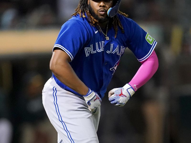 Sep 5, 2023; Oakland, California, USA; Toronto Blue Jays first baseman Vladimir Guerrero Jr. (27) flexes after being intentionally walked against the Oakland Athletics in the seventh inning at Oakland-Alameda County Coliseum. Mandatory Credit: Cary Edmondson-USA TODAY Sports