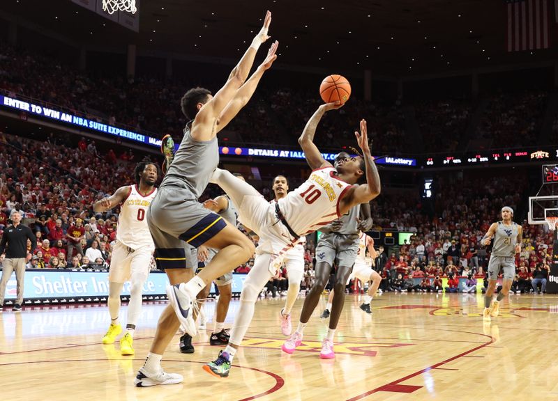 Feb 24, 2024; Ames, Iowa, USA; Iowa State Cyclones guard Keshon Gilbert (10) is defended by West Virginia Mountaineers center Jesse Edwards (7) during the first half at James H. Hilton Coliseum. Mandatory Credit: Reese Strickland-USA TODAY Sports