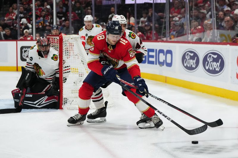 Nov 12, 2023; Sunrise, Florida, USA; Florida Panthers center Steven Lorentz (18) plays the puck in front of Chicago Blackhawks defenseman Wyatt Kaiser (44) during the second period at Amerant Bank Arena. Mandatory Credit: Jasen Vinlove-USA TODAY Sports