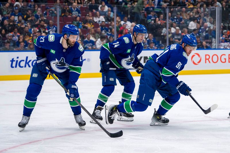 Oct 4, 2024; Vancouver, British Columbia, CAN; Vancouver Canucks defenseman Derek Forbort (27) and forward Jake DeBrusk (74) and forward Daniel Sprong (91) during a face-off against the Edmonton Oilers during the second period at Rogers Arena. Mandatory Credit: Bob Frid-Imagn Images