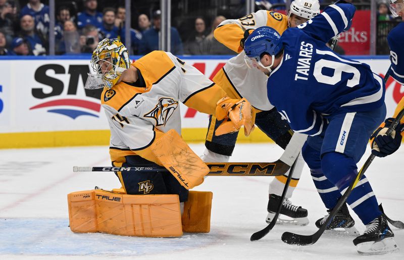 Dec 4, 2024; Toronto, Ontario, CAN;  Nashville Predators goalie Jusse Saros (74) looks for the puck after making a save against Toronto Maple Leafs forward John Tavares (91) in the first period at Scotiabank Arena. Mandatory Credit: Dan Hamilton-Imagn Images