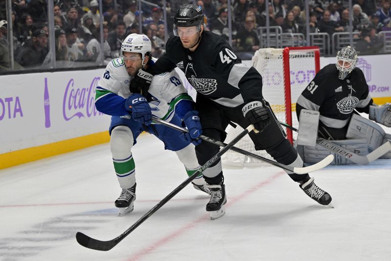 Nov 29, 2025; Los Angeles, California, USA; Vancouver Canucks left wing Arshdeep Bains (13) and Los Angeles Kings right wing Joel Armia (40) battle for the puck during the first period at Crypto.com Arena. Mandatory Credit: Jayne Kamin-Oncea-Imagn Images