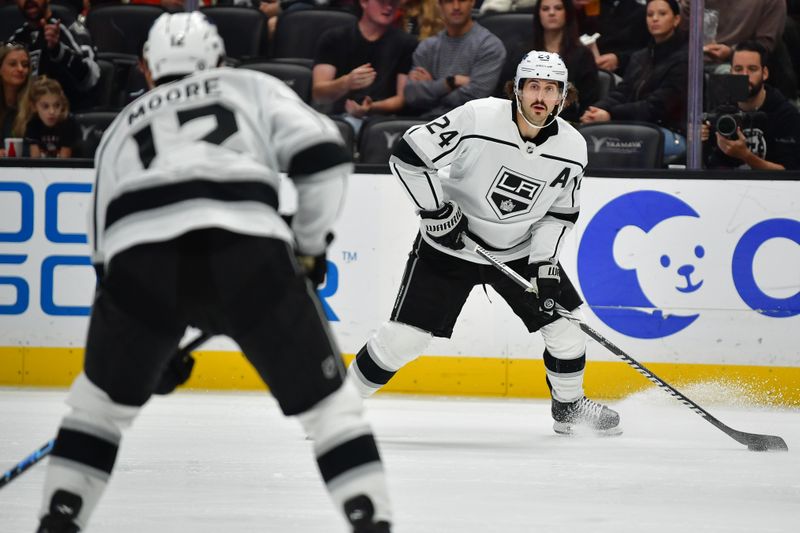 Nov 24, 2023; Anaheim, California, USA; Los Angeles Kings center Phillip Danault (24) passes the puck to center Trevor Moore (12) against the Anaheim Ducks during the third period at Honda Center. Mandatory Credit: Gary A. Vasquez-USA TODAY Sports