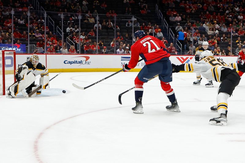 Oct 5, 2024; Washington, District of Columbia, USA; Washington Capitals center Aliaksei Protas (21) shoots the puck on Boston Bruins goaltender Brandon Bussi (30) as Bruins defenseman Billy Sweezey (58) defends in the third period at Capital One Arena. Mandatory Credit: Geoff Burke-Imagn Images