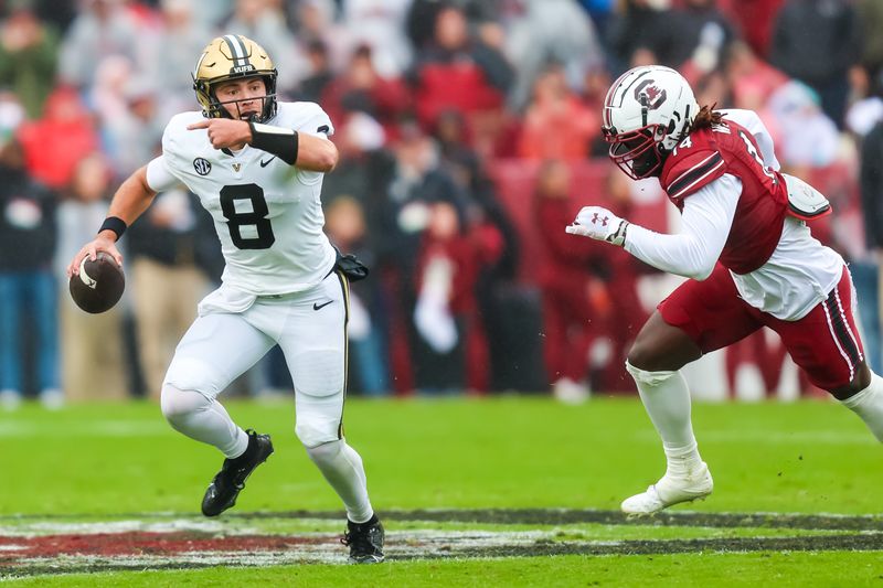 Nov 11, 2023; Columbia, South Carolina, USA; Vanderbilt Commodores quarterback Ken Seals (8) rolls out against South Carolina Gamecocks linebacker Jaron Willis (14) in the second quarter at Williams-Brice Stadium. Mandatory Credit: Jeff Blake-USA TODAY Sports