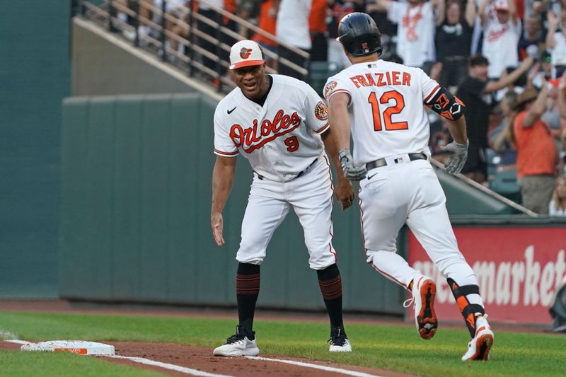 Jul 30, 2023; Baltimore, Maryland, USA; Baltimore Orioles outfielder Adam Frazier (12) greeted by coach Anthony Sanders (9) following his three-run home run in the first inning against the New York Yankees at Oriole Park at Camden Yards. Mandatory Credit: Mitch Stringer-USA TODAY Sports