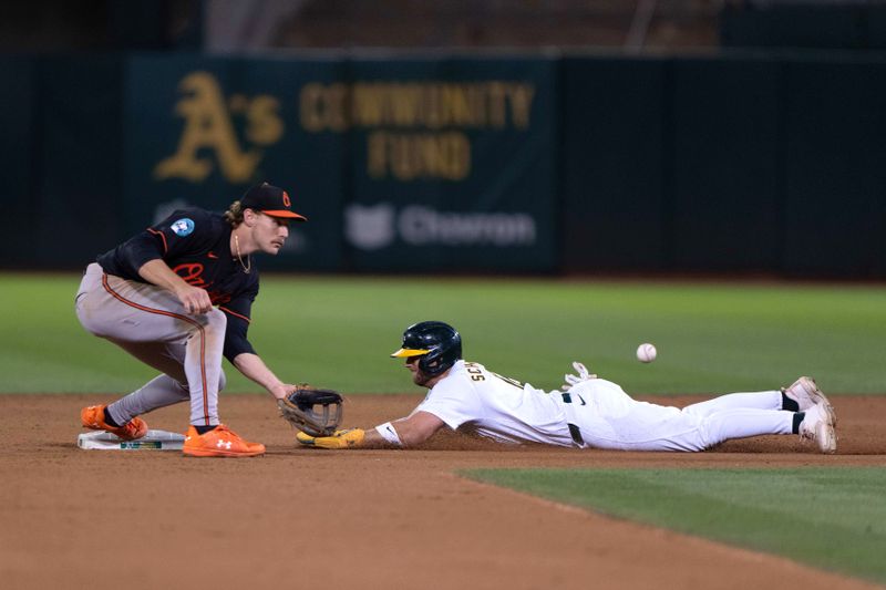 Jul 5, 2024; Oakland, California, USA;  Oakland Athletics shortstop Max Schuemann (12) slides safely into second base during the eighth inning against Baltimore Orioles shortstop Gunnar Henderson (2) at Oakland-Alameda County Coliseum. Mandatory Credit: Stan Szeto-USA TODAY Sports