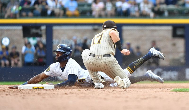 Aug 27, 2023; Milwaukee, Wisconsin, USA; Milwaukee Brewers second baseman Andruw Monasterio (14) slides safely into second base ahead of the tag by San Diego Padres second baseman Matthew Batten (17) in the seventh inning at American Family Field. Mandatory Credit: Michael McLoone-USA TODAY Sports