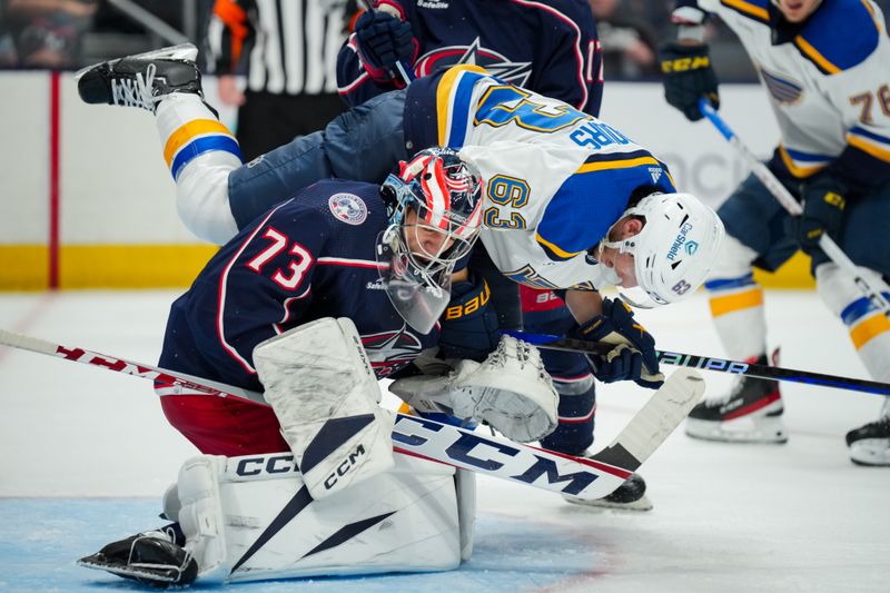 Oct 2, 2023; Columbus, Ohio, USA;  St. Louis Blues left wing Jake Neighbours (63) falls after he collides with Columbus Blue Jackets goaltender Jet Greaves (73) in the second period at Nationwide Arena. Mandatory Credit: Aaron Doster-USA TODAY Sports