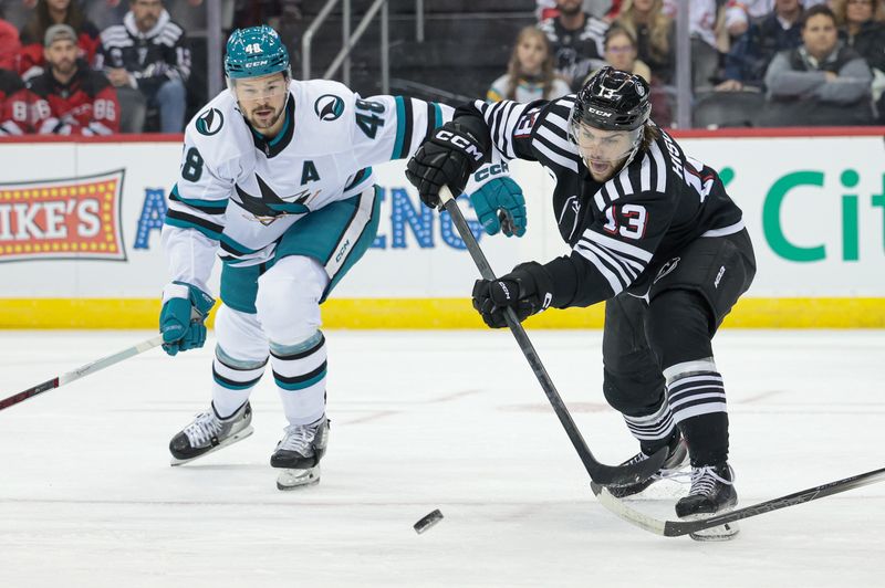 Dec 1, 2023; Newark, New Jersey, USA; New Jersey Devils center Nico Hischier (13) passes the puck during the first period as San Jose Sharks center Tomas Hertl (48) defends at Prudential Center. Mandatory Credit: Vincent Carchietta-USA TODAY Sports