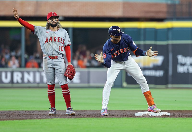 Sep 22, 2024; Houston, Texas, USA; Houston Astros shortstop Jeremy Pena (3) celebrates and Los Angeles Angels second baseman Jack Lopez (10) reacts after a double by Pena during the second inning at Minute Maid Park. Mandatory Credit: Troy Taormina-Imagn Images