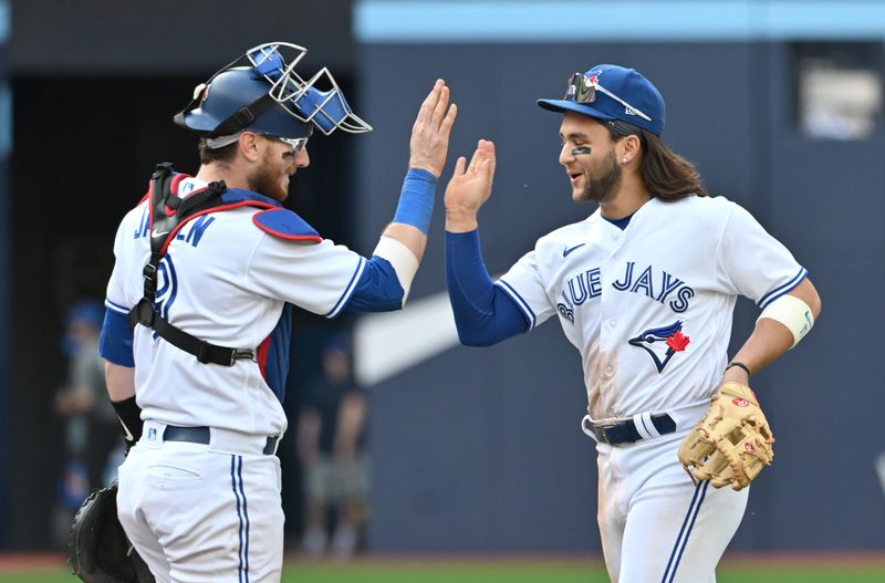 May 13, 2023; Toronto, Ontario, CAN; Toronto Blue Jays catcher Danny Jansen (9) and shortstop Bo Bichette (11) celebrate a win over the Atlanta Braves at Rogers Centre. Mandatory Credit: Dan Hamilton-USA TODAY Sports