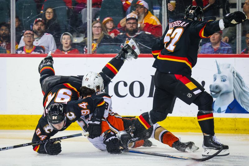 Apr 2, 2024; Calgary, Alberta, CAN; Anaheim Ducks center Mason McTavish (23) collides with Calgary Flames defenseman Brayden Pachal (94) and defenseman MacKenzie Weegar (52) during the second period at Scotiabank Saddledome. Mandatory Credit: Sergei Belski-USA TODAY Sports