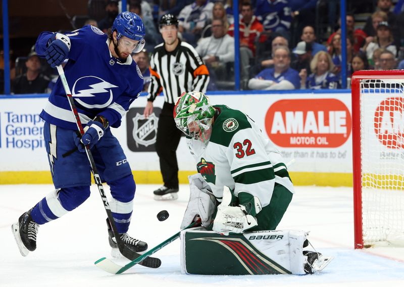 Jan 18, 2024; Tampa, Florida, USA; Minnesota Wild goaltender Filip Gustavsson (32) makes a save as Tampa Bay Lightning center Anthony Cirelli (71) skates during the first period at Amalie Arena. Mandatory Credit: Kim Klement Neitzel-USA TODAY Sports