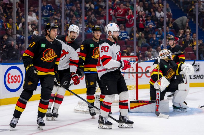 Oct 30, 2024; Vancouver, British Columbia, CAN; Vancouver Canucks defenseman Noah Juulsen (47) and forward Pius Suter (24) and goalie Arturs Silovs (31) react as New Jersey Devils defenseman Jonas Siegenthaler (71) and forward Tomas Tatar (90) celebrate Tatar’s goal during the third period at Rogers Arena. Mandatory Credit: Bob Frid-Imagn Images