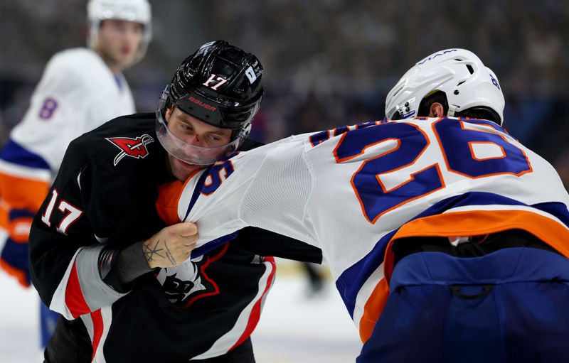 Nov 1, 2024; Buffalo, New York, USA;  Buffalo Sabres left wing Jason Zucker (17) and New York Islanders right wing Oliver Wahlstrom (26) fight during the second period at KeyBank Center. Mandatory Credit: Timothy T. Ludwig-Imagn Images