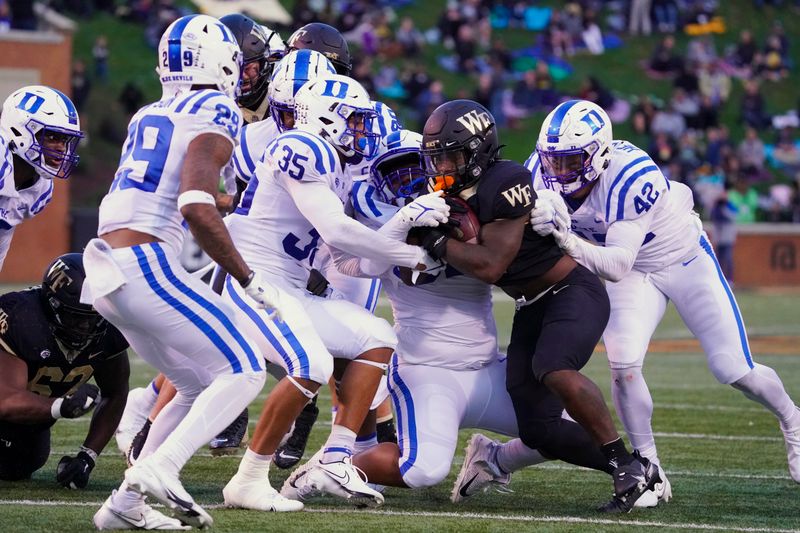 Oct 30, 2021; Winston-Salem, North Carolina, USA; Wake Forest Demon Deacons running back Christian Turner (0) is stopped by Duke Blue Devils linebacker Dorian Mausi (35) and defensive tackle Aeneas Peebles (92) and linebacker Shaka Heyward (42) during the second half at Truist Field. Mandatory Credit: James Guillory-USA TODAY Sports
