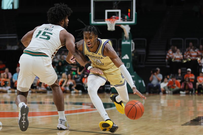 Feb 24, 2024; Coral Gables, Florida, USA; Georgia Tech Yellow Jackets guard Miles Kelly (13) drives to the basket against Miami Hurricanes forward Norchad Omier (15) during the first half at Watsco Center. Mandatory Credit: Sam Navarro-USA TODAY Sports