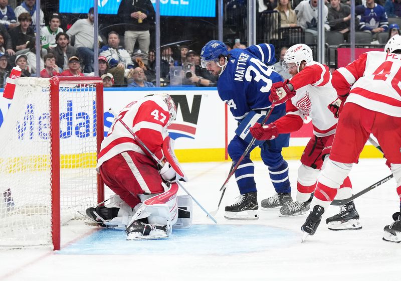 Apr 13, 2024; Toronto, Ontario, CAN; Toronto Maple Leafs center Auston Matthews (34) battles for the puck with Detroit Red Wings left wing J.T. Compher (37) during the third period at Scotiabank Arena. Mandatory Credit: Nick Turchiaro-USA TODAY Sports