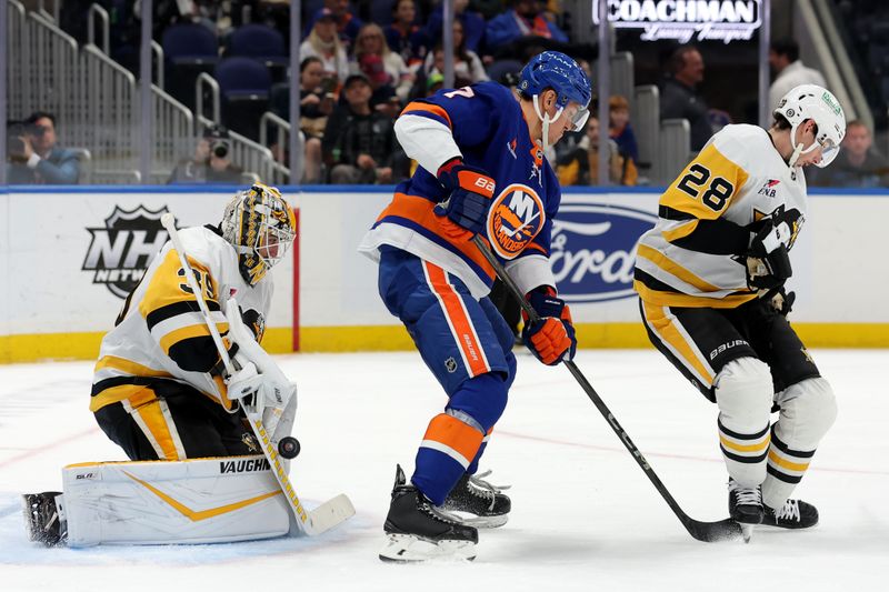 Nov 5, 2024; Elmont, New York, USA; Pittsburgh Penguins goaltender Alex Nedeljkovic (39) makes a save against in front of New York Islanders right wing Maxim Tsyplakov (7) and Penguins defenseman Marcus Pettersson (28) during the second period at UBS Arena. Mandatory Credit: Brad Penner-Imagn Images