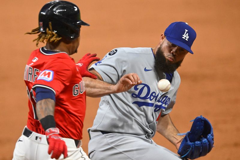 May 27, 2025; Cleveland, Ohio, USA; Los Angeles Dodgers relief pitcher Luis Garcia (57) drops the ball while covering first base allowing Cleveland Guardians third baseman Jose Ramirez (11) to reach on an error in the ninth inning at Progressive Field. Mandatory Credit: David Richard-Imagn Images