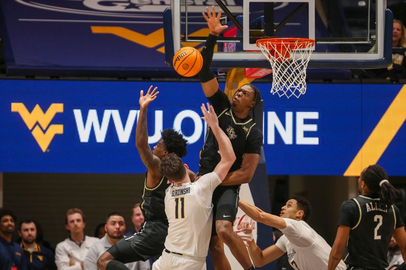 Feb 20, 2024; Morgantown, West Virginia, USA; UCF Knights forward Omar Payne (5) blocks a shot from West Virginia Mountaineers forward Quinn Slazinski (11) during the first half at WVU Coliseum. Mandatory Credit: Ben Queen-USA TODAY Sports