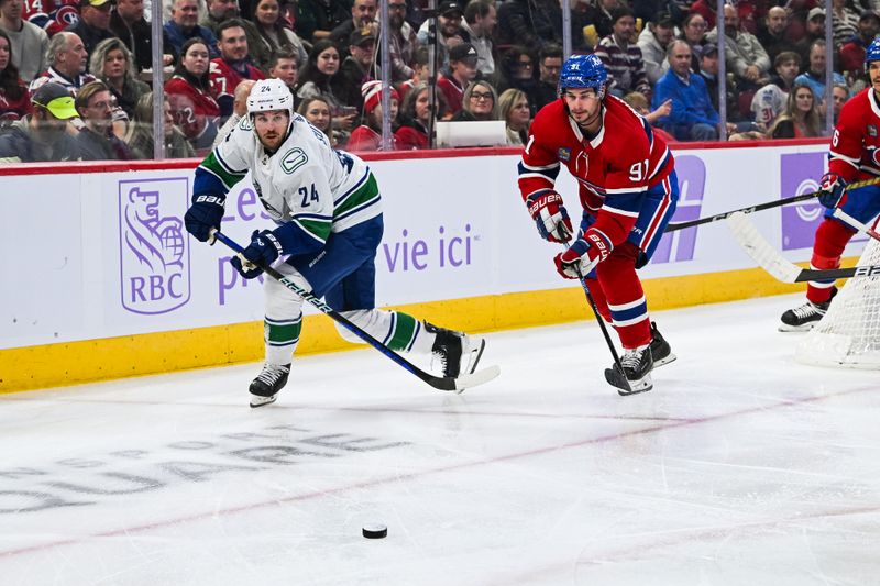 Nov 12, 2023; Montreal, Quebec, CAN; Vancouver Canucks center Pius Suter (24) passes the puck as Montreal Canadiens center Sean Monahan (91) defends during the first period at Bell Centre. Mandatory Credit: David Kirouac-USA TODAY Sports