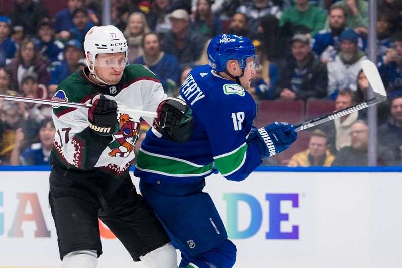 Jan 18, 2024; Vancouver, British Columbia, CAN; Arizona Coyotes forward Nick Bjugstad (17) checks Vancouver Canucks forward Sam Lafferty (18) in the first period at Rogers Arena. Mandatory Credit: Bob Frid-USA TODAY Sports