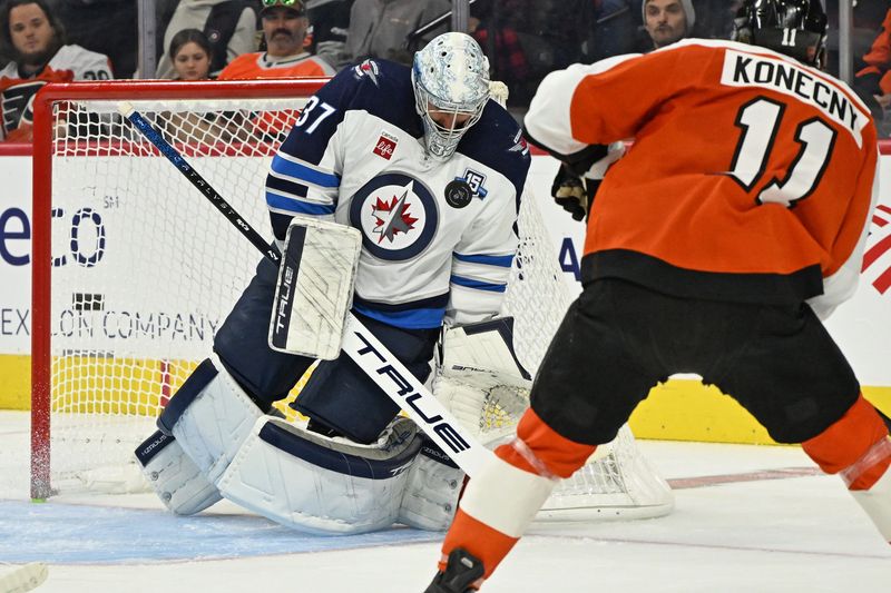 Oct 16, 2025; Philadelphia, Pennsylvania, USA; Winnipeg Jets goaltender Connor Hellebuyck (37) makes a save against Philadelphia Flyers right wing Travis Konecny (11) during the second period at Wells Fargo Center. Mandatory Credit: Eric Hartline-Imagn Images