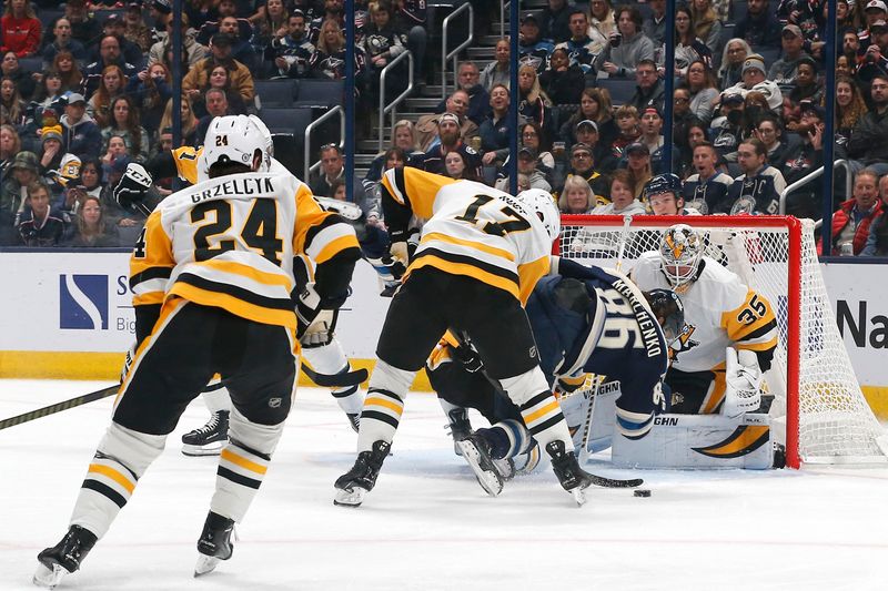 Nov 15, 2024; Columbus, Ohio, USA; Columbus Blue Jackets right wing Kirill Marchenko (86) falls to the ice as he reaches for the rebound of Pittsburgh Penguins goalie Tristan Jarry (35) save during the first period at Nationwide Arena. Mandatory Credit: Russell LaBounty-Imagn Images