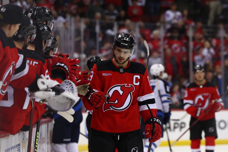 Mar 21, 2024; Newark, New Jersey, USA; New Jersey Devils center Nico Hischier (13) celebrates his goal against the Winnipeg Jets during the third period at Prudential Center. Mandatory Credit: Ed Mulholland-USA TODAY Sports