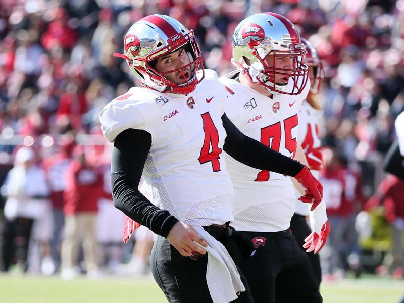 Nov 9, 2019; Fayetteville, AR, USA; Western Kentucky Hilltoppers quarterback Ty Storey (4) celebrates after scoring a touchdown in the second quarter against the Arkansas Razorbacks at Donald W. Reynolds Razorback Stadium. Mandatory Credit: Nelson Chenault-USA TODAY Sports