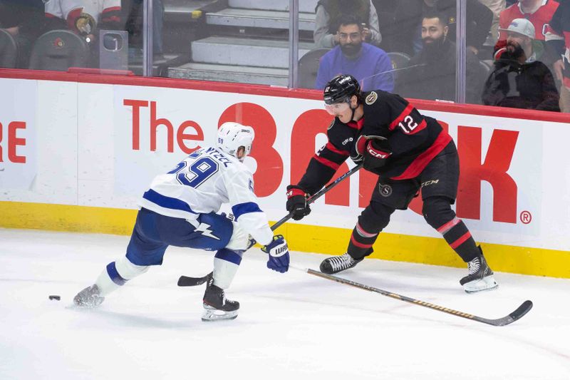 Oct 19, 2024; Ottawa, Ontario, CAN; Ottawa Senators center Shane Pinto (12) moves the puck away from Tampa Bay Lightning center Jake Guentzel (59) in the third period at the Canadian Tire Centre. Mandatory Credit: Marc DesRosiers-Imagn Images