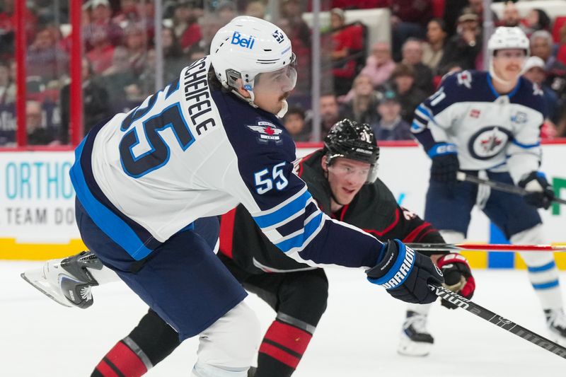 Nov 28, 2025; Raleigh, North Carolina, USA;  Winnipeg Jets center Mark Scheifele (55) scores a goal on his shot against the Carolina Hurricanes during the second period at Lenovo Center. Mandatory Credit: James Guillory-Imagn Images