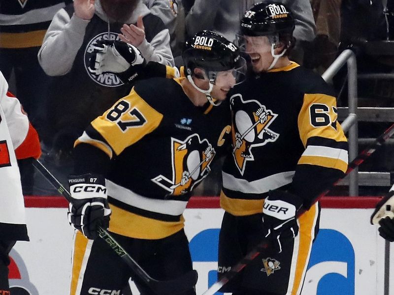 Feb 25, 2024; Pittsburgh, Pennsylvania, USA;  Pittsburgh Penguins center Sidney Crosby (87) congratulates right wing Rickard Rakell (67) on his goal against the Philadelphia Flyers during the third period at PPG Paints Arena.  Pittsburgh won 7-6. Mandatory Credit: Charles LeClaire-USA TODAY Sports