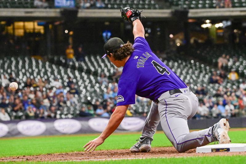 Sep 6, 2024; Milwaukee, Wisconsin, USA; Colorado Rockies first baseman Michael Toglia (4) can't catch a throwing error by Colorado Rockies second baseman Aaron Schunk (not pictured) allowing a run to score in the seventh inning against the Milwaukee Brewers at American Family Field. Mandatory Credit: Benny Sieu-Imagn Images