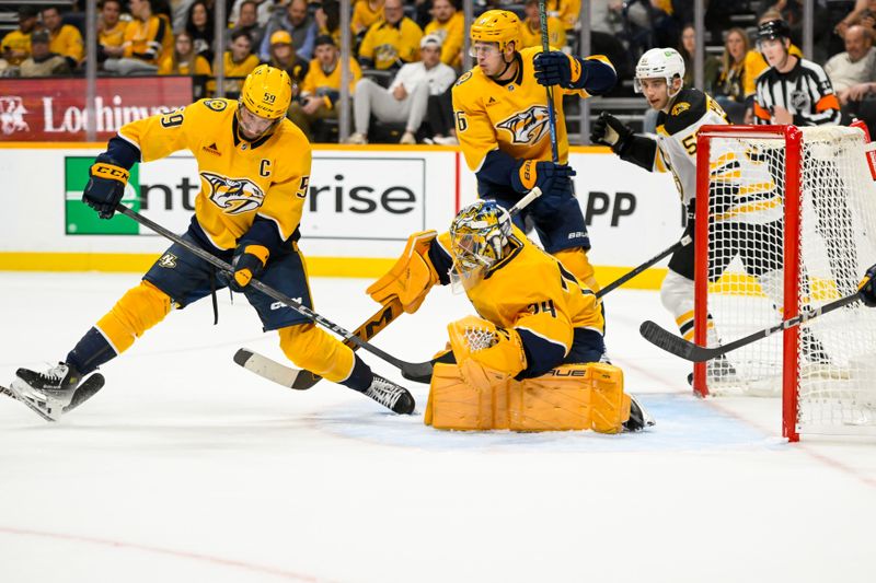 Oct 22, 2024; Nashville, Tennessee, USA;  Nashville Predators goaltender Juuse Saros (74) blocks a shot against the Boston Bruins during the second period at Bridgestone Arena. Mandatory Credit: Steve Roberts-Imagn Images