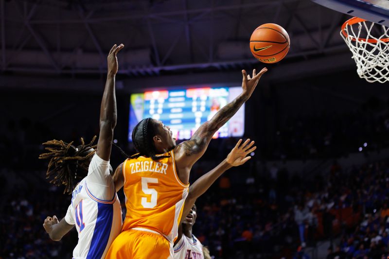 Jan 7, 2025; Gainesville, Florida, USA; Tennessee Volunteers guard Zakai Zeigler (5) makes a layup over Florida Gators guard Denzel Aberdeen (11) during the first half at Exactech Arena at the Stephen C. O'Connell Center. Mandatory Credit: Matt Pendleton-Imagn Images