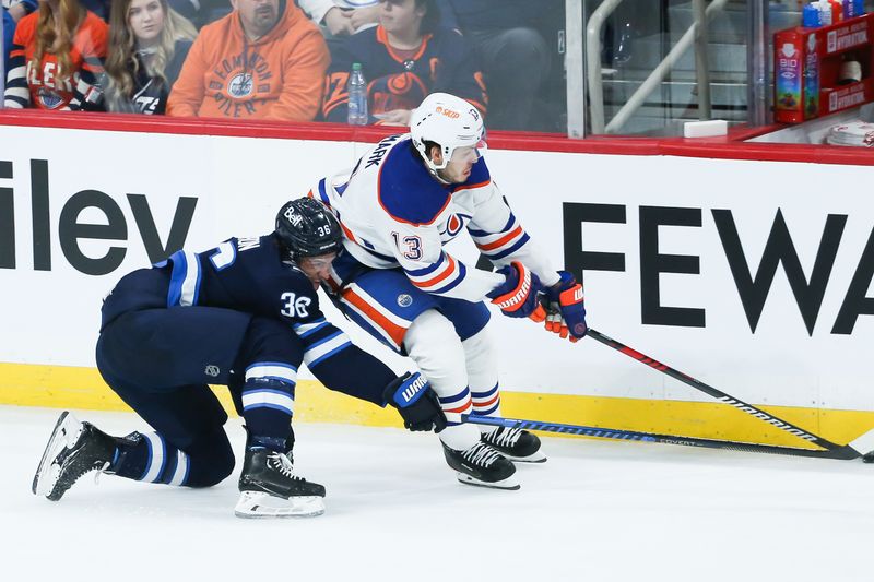 Nov 30, 2023; Winnipeg, Manitoba, CAN; Edmonton Oilers forward Mattias Janmark (13) skates away from Winnipeg Jets forward Morgan Barron (36) during the third period at Canada Life Centre. Mandatory Credit: Terrence Lee-USA TODAY Sports