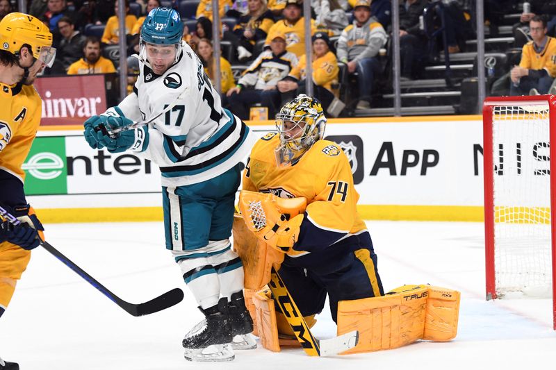 Mar 19, 2024; Nashville, Tennessee, USA; Nashville Predators goaltender Juuse Saros (74) makes a save with a screen from San Jose Sharks center Thomas Bordeleau (17) during the second period at Bridgestone Arena. Mandatory Credit: Christopher Hanewinckel-USA TODAY Sports