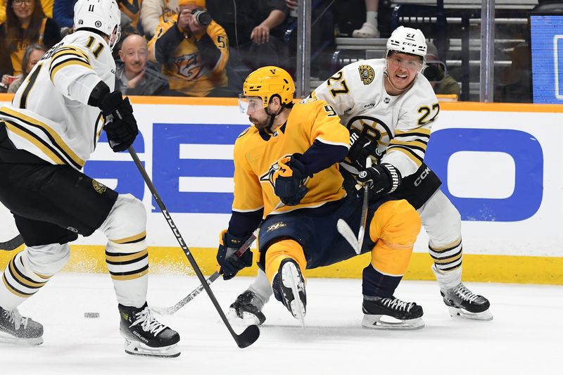 Apr 2, 2024; Nashville, Tennessee, USA; Nashville Predators left wing Filip Forsberg (9) tries to keep the puck as he is defended by Boston Bruins defenseman Hampus Lindholm (27) and center Trent Frederic (11) during the first period at Bridgestone Arena. Mandatory Credit: Christopher Hanewinckel-USA TODAY Sports