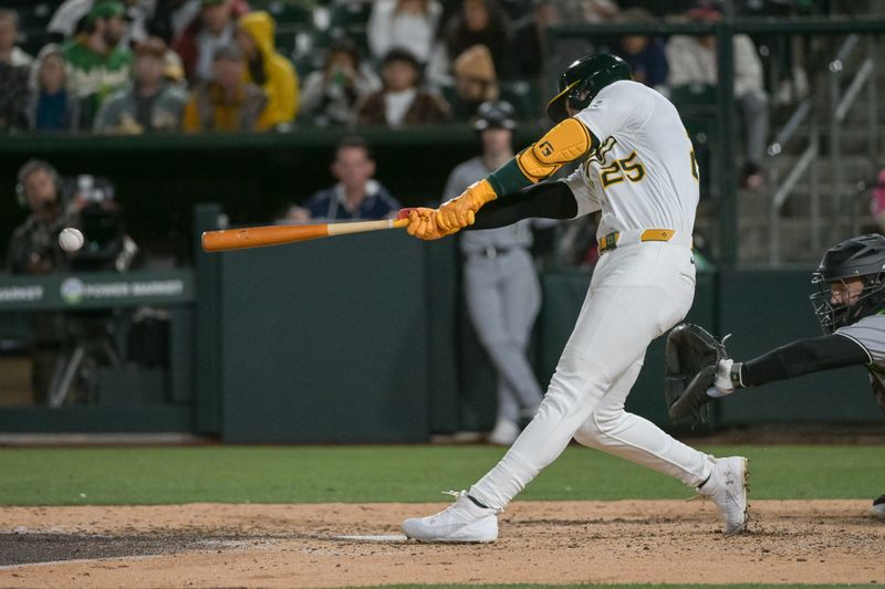 Apr 25, 2025; West Sacramento, California, USA; Athletics outfielder Brent Rooker (25) hits an RBI double against the Chicago White Sox during the seventh inning at Sutter Health Park. Mandatory Credit: Ed Szczepanski-Imagn Images