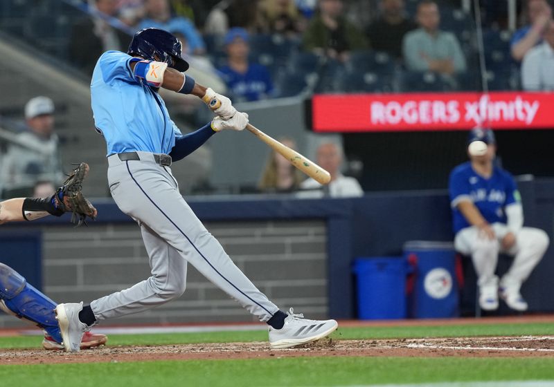 May 13, 2025; Toronto, Ontario, CAN; Tampa Bay Rays left field Chandler Simpson (14) hits an RBI single against the Toronto Blue Jays during the ninth inning at Rogers Centre. Mandatory Credit: Nick Turchiaro-Imagn Images