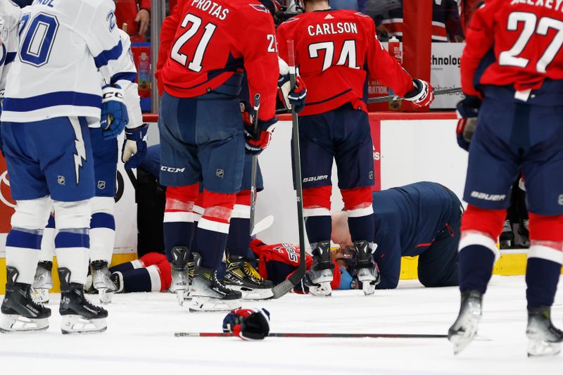 Apr 13, 2024; Washington, District of Columbia, USA; Washington Capitals head trainer Jason Serbus tends to injured Washington Capitals defenseman Nick Jensen (3) after a hit by Tampa Bay Lightning center Michael Eyssimont (not pictured) in the first period at Capital One Arena. Mandatory Credit: Geoff Burke-USA TODAY Sports