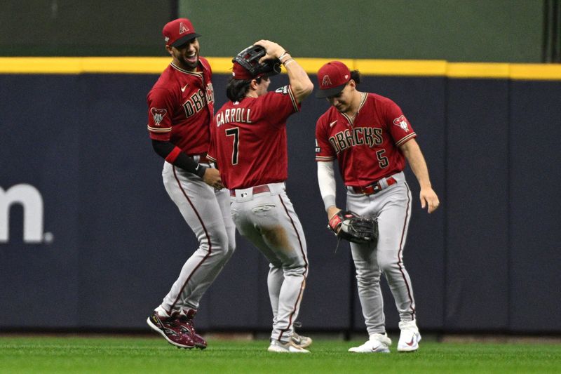 Oct 3, 2023; Milwaukee, Wisconsin, USA; Arizona Diamondbacks left fielder Lourdes Gurriel Jr. (12) and center fielder Alek Thomas (5) and left fielder Corbin Carroll (7) celebrate after defeating the Milwaukee Brewers in game one of the Wildcard series for the 2023 MLB playoffs at American Family Field. Mandatory Credit: Michael McLoone-USA TODAY Sports